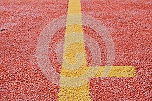 Yellow line on red playing field. Copy space. Sport texture and background