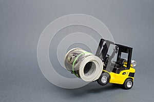 A yellow loader stands on the rear wheels holding a big bundle of dollars. concept of attracting investment, issuing concessional photo