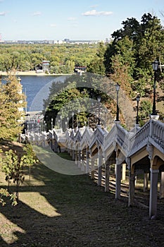 Yellow long staircase with vintage lanterns at sunny day. They connect Dnieper embankment with Volodimirsky descent