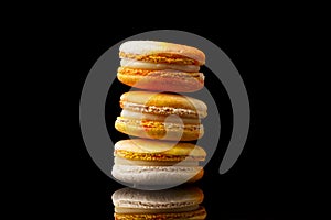 Yellow macaroon cookies on a black background