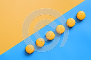 Yellow macaroons on a double yellow-blue background. Creative layout. Top view, flat lay, copy space