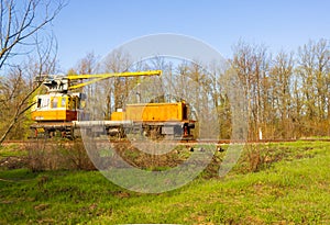 Yellow maintenance train parked on rails used for railroad maintenance