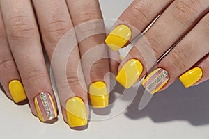 Yellow manicure nail design with stones