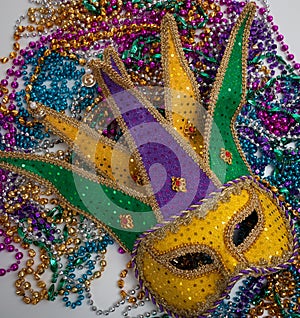 A yellow Mardi Gras mask and beads