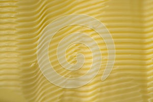 Yellow margarine texture full frame close up. Grooves made by knife