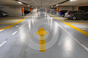 Yellow markings with blurred modern cars parked inside closed underground parking lot