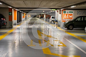 Yellow markings with blurred modern cars parked inside closed underground parking lot