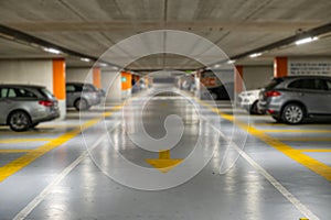 Yellow markings with blurred modern cars parked inside closed underground parking lot