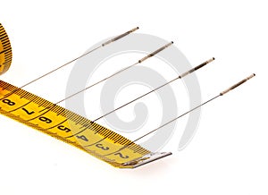 Yellow measuring tape isolated on white background. Measuring tape with needles for acupuncture. Close up