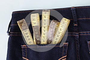 Yellow measuring tape in jeans pocket image of body slimming