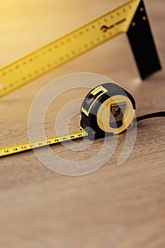 Yellow Measuring Tape on white/wood background