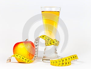 A yellow measuring tape wrapping red apple and juice