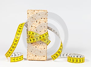 A yellow measuring tape wrapping wheat cracker or crispbread
