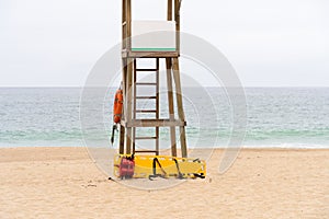 Yellow medical backboard and life ring on wooden lifeguard tower