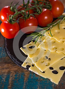 Yellow medium-hard mild Swiss cheese Emmental, fresh rosemary an