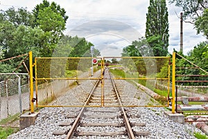 Yellow metal fence across the railroad
