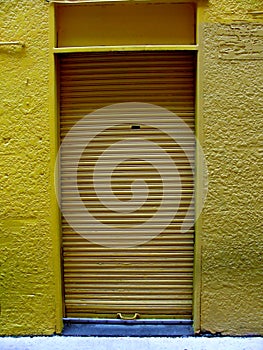 Yellow metal roller shutter door at Vancouver, Canada