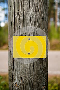 Yellow metal sign board signage on wooden pole