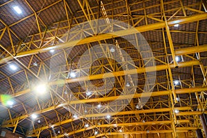 Yellow metal structure on roof with lamp lighting in storehouse