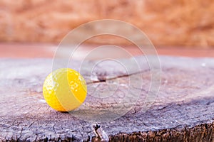 Yellow Miniature Golf Ball On Wood Background.