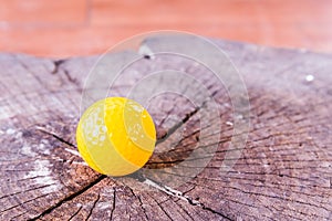 Yellow Miniature Golf Ball On Wood Background.