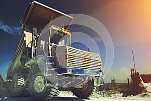 Yellow mining truck. Work industrial machinery, limestone mining. Sun light effect