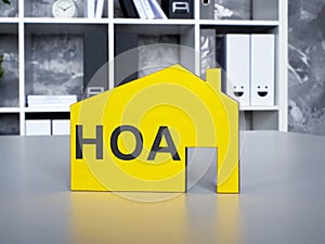 A Yellow model of house with Homeowners Association HOA inscription.