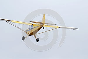 Yellow monomotor airplane low flight