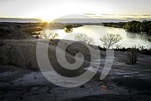 Yellow Moon Valley that borders a great river, a surface of stones and a sky full of clouds