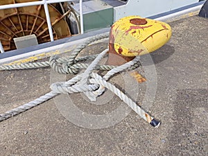 Yellow mooring bollard with ropes