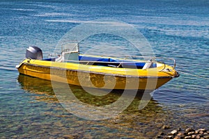 Yellow motor boat moored to the sea shore