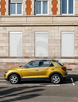 Yellow mustard color of new Volkswagen VW T-Roc SUV parked in front of French