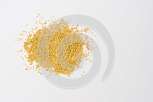 Yellow mustard seeds on white photo