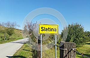 Yellow nameplate of town Slatina near road in Croatia