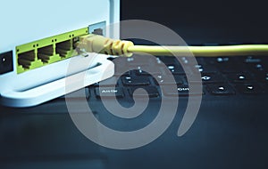 Yellow network cable connected to a router on the laptop.