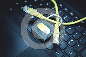 Yellow network cable with a padlock on the laptop. Web security concept