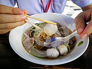 Yellow noodles with meat ball in clear broth or soup