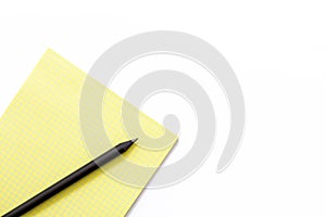 Yellow notebook and black pencil on a white background. Minimal business concept.