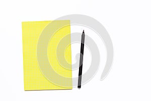 Yellow notebook and black pencil on a white background. Minimal business concept for office.