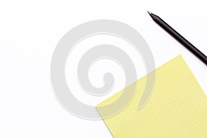 Yellow notebook and black pencil on a white background. Minimal business concept.