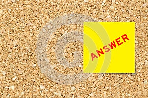 Yellow notepaper with word answer on cork board background with copy space