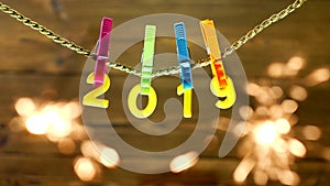 Yellow numbers 2019 hanging on a clothespin on a rope on a wooden background, close-up, New Year 2019, Christmas, they