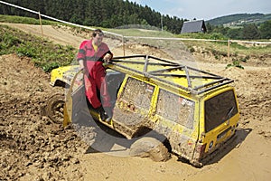 Yellow off road car drowned in muddy terrain