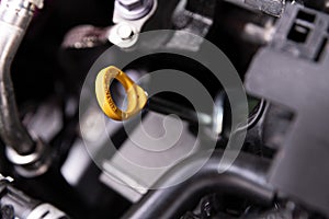 Yellow oil dipstick in car engine