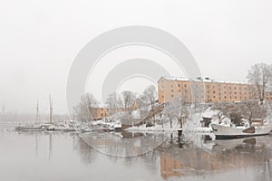 Yellow old buildings of Skeppsholmen island in Stockholm with white snow in winter