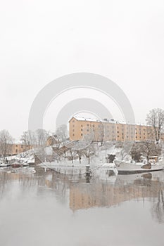 Yellow old buildings of Skeppsholmen island in Stockholm with white snow in winter