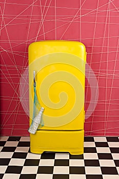 Yellow old vintage retro refrigerator on a pink background with