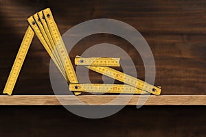 Yellow Old Wooden Folding Ruler Above a Wooden Shelf