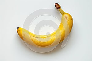 Yellow one Banana isolated on White background. A yellow banana sits on top of a white table, creating a simple and minimalist