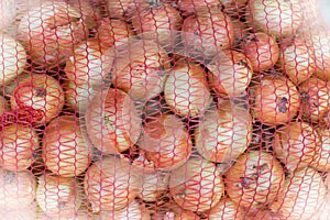 Yellow onions in a red net bag